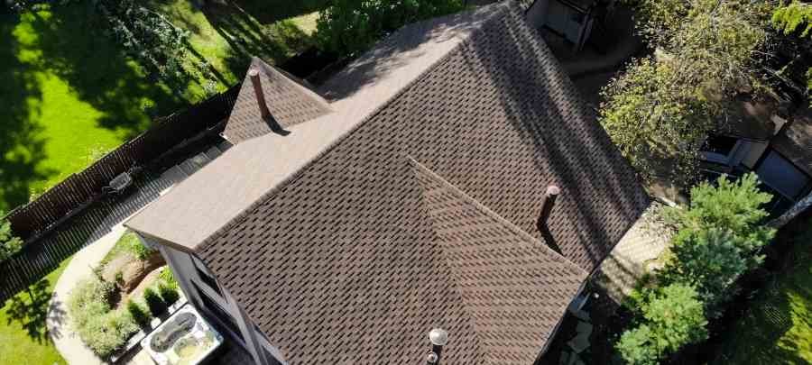 Aerial view of an older home roof that may create homeowners insurance questions before closing